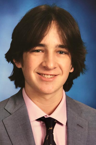 Male wearing a grey suit smiling at the camera